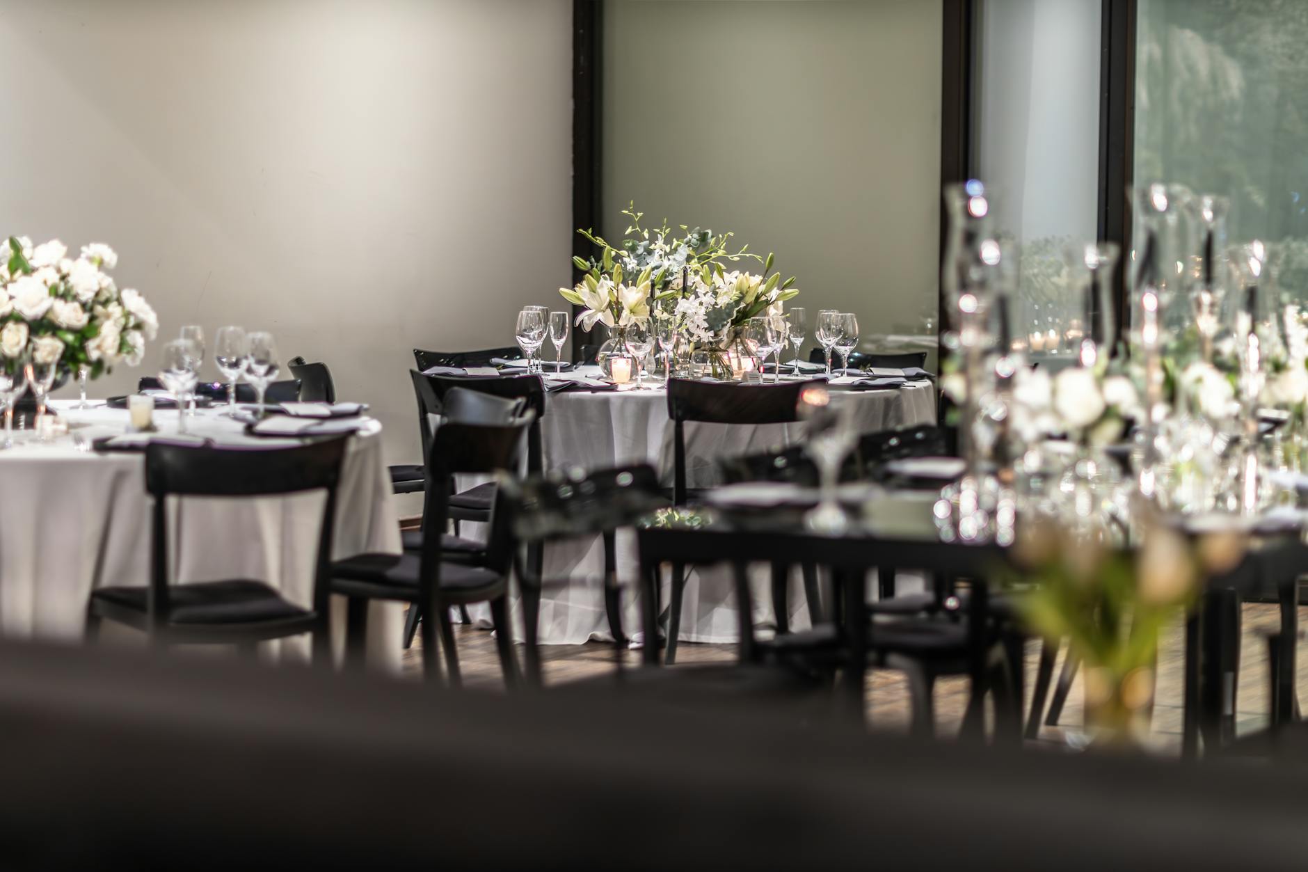 Elegancko nakryty stół weselny z białymi kwiatami i kieliszkami