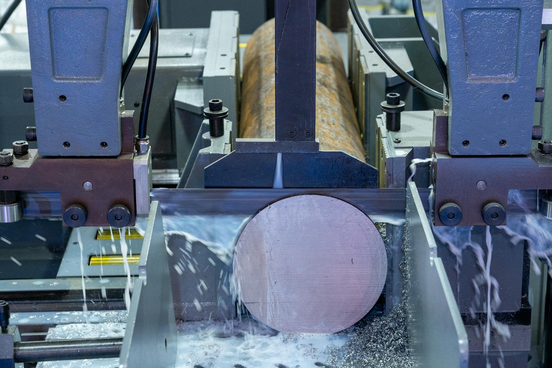 Zbliżenie na maszynę przemysłową precyzyjnie tnącą metalowy pręt