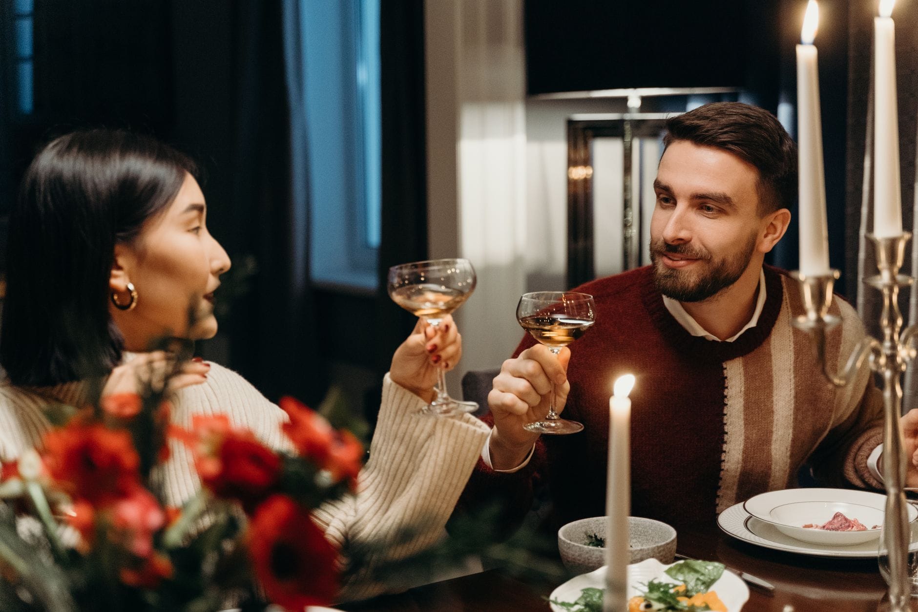 Para przy romantycznej kolacji przy świecach i winie w przytulnym domu