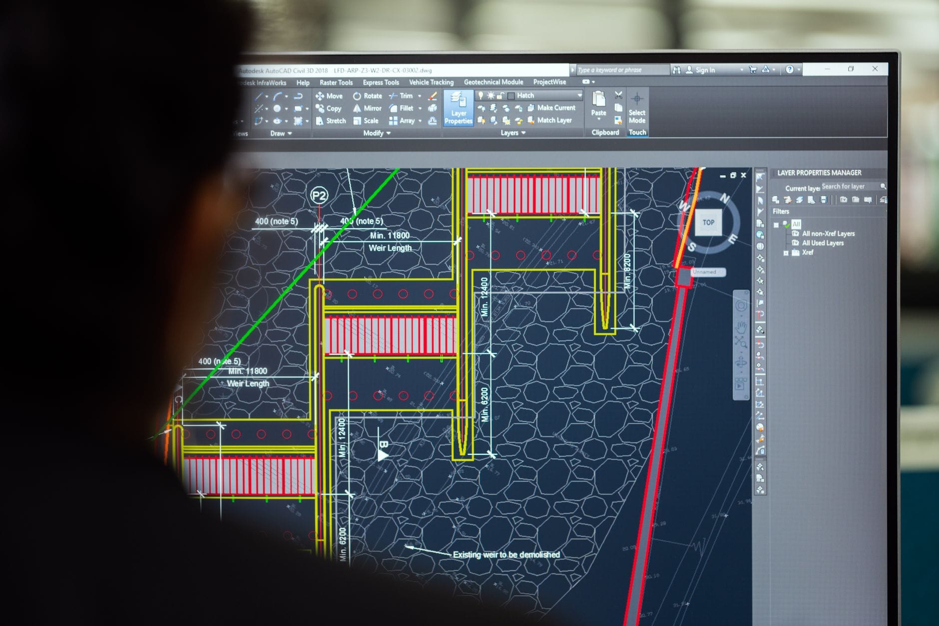Zamiana tekstu na krzywe w DXF: kiedy to konieczne przy wycinaniu WaterJet Inżynier pracujący przy projekcie w CAD na monitorze w biurze