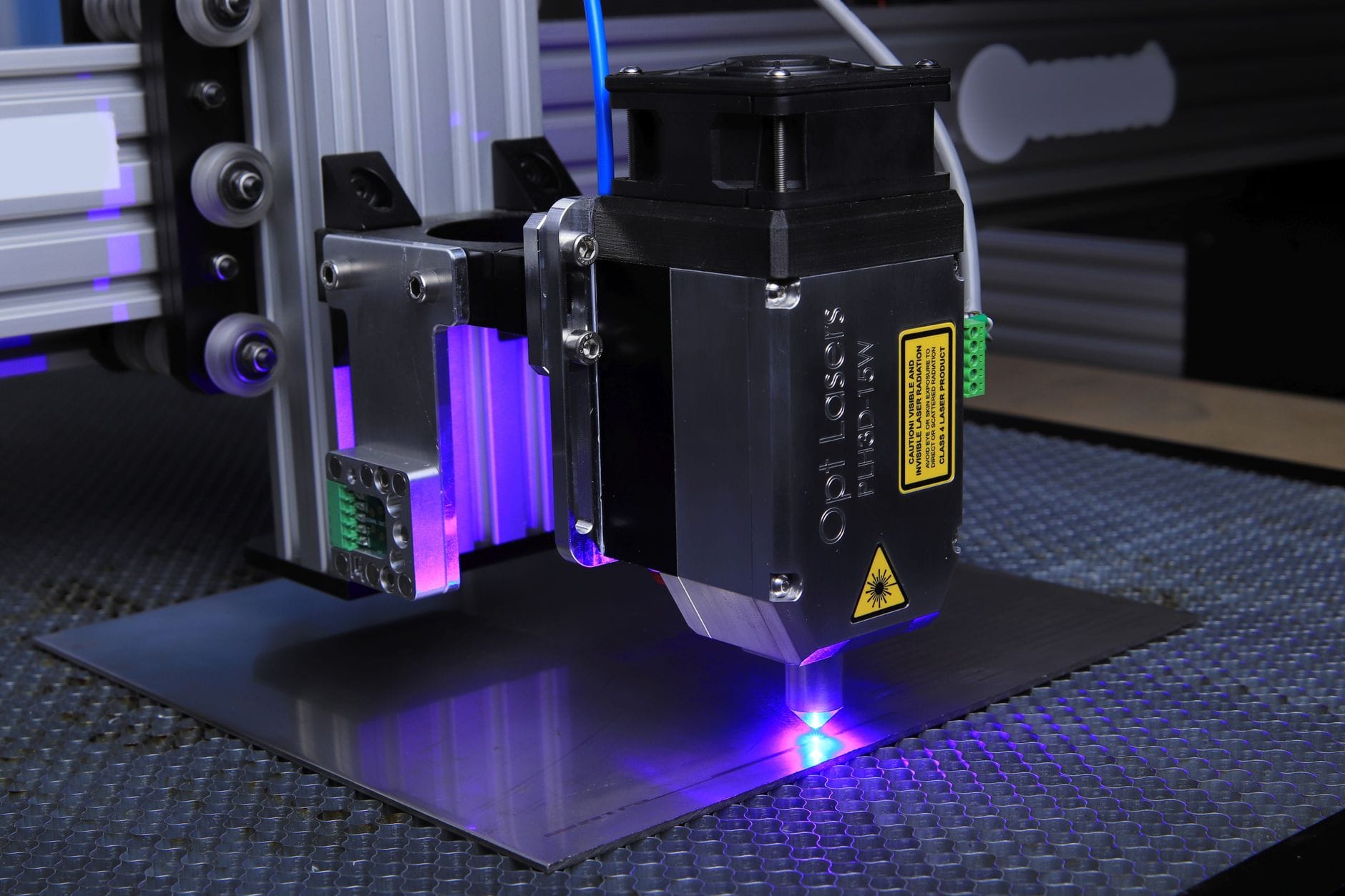 Zbliżenie na maszynę laserową grawerującą powierzchnię metalową